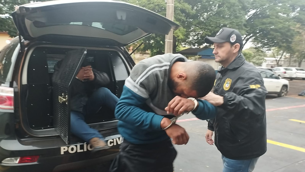 Momento em que os dois acusados chegavam à delegacia em Dourados (Foto: Leandro Holsbach)